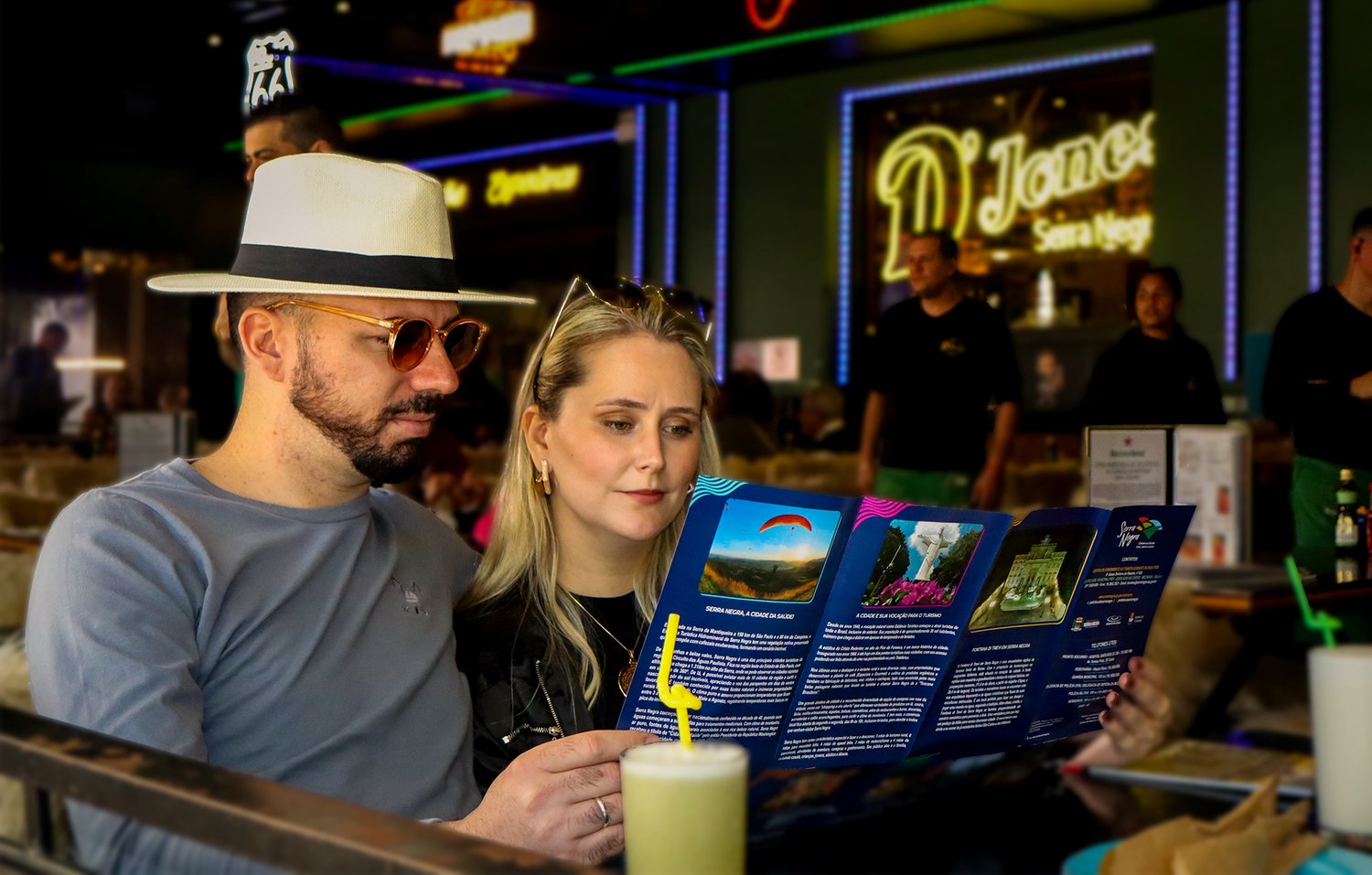 Casal folheando o folheto turístico de Serra Negra num restaurante da cidade